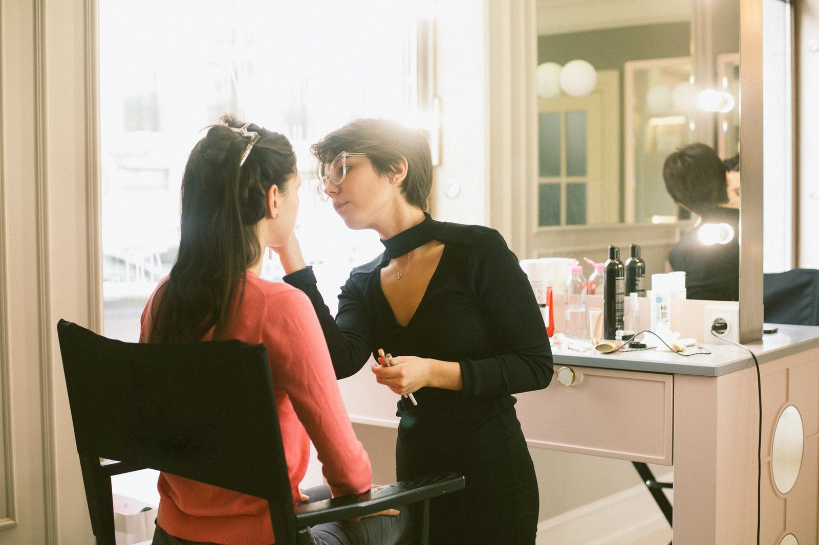 young female makeup artist doing makeup to customer