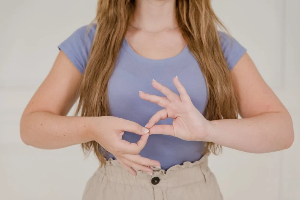 close up on womans hands while using sign language
