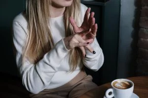woman in white long sleeve shirt doing sign language